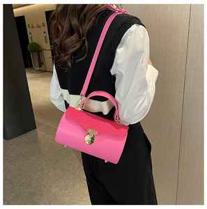Detailed view of hot pink crossbody box bag with striped flap and gold circular lock