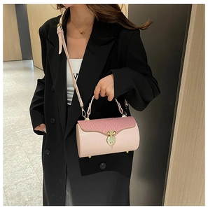 Pink cylinder box bag with pleated texture and vintage gold buckle shown as crossbody style