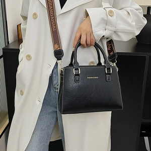 Chic black pebble leather tote bag with wide jacquard strap for women's crossbody wear