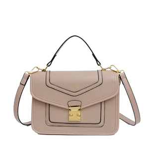 Beige faux leather crossbody bag with lychee texture and gold clasp on white background