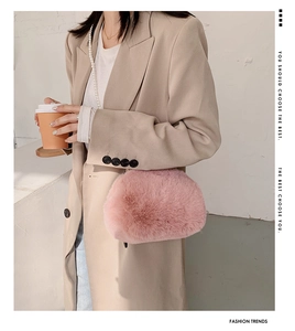 Detailed view of pink plush crossbody bag featuring elegant pearl strap on model outfit