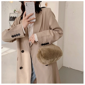Detail of soft brown plush crossbody bag with delicate metal chain strap on model