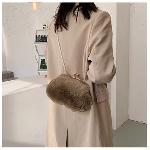 Brown faux fur pearl strap crossbody bag shown from the back on a beige suit