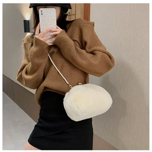 Detail of plush crossbody bag with faux fur texture and elegant pearl chain strap
