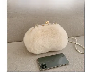 Faux fur shell bag size comparison with smartphone showing pearl strap and metal clasp
