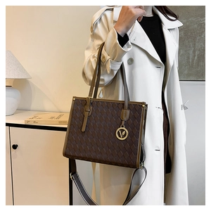 Detail of vintage embossed checkerboard tote bag with gold V-pendant and dual straps