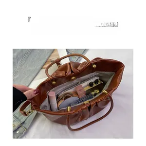 Vue intérieure du sac seau plissé caramel montrant une grande capacité pour essentiels