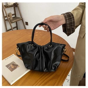 Détail du sac nuage froncé noir avec poignée tissée et finitions dorées élégantes