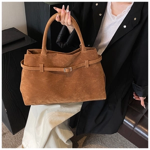 Detailed view of brown matte suede tote bag with decorative silver buckle and strap