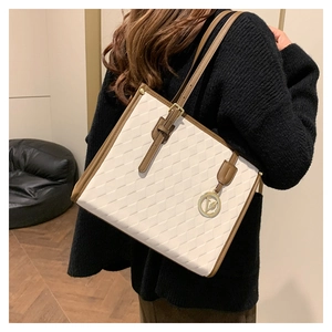 Detail of vintage tote bag with white textured pattern and brown leather trim on a model