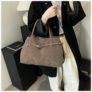 Detailed shot of dark brown frosted leather tote bag with silver metal buckle and strap