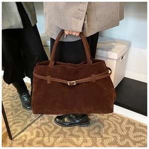 Close-up of vintage brown suede tote bag featuring metallic buckle and belt detail