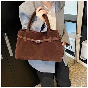 Detailed close-up of dark brown matte suede tote bag with stylish metal buckle and strap