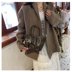 Détail du sac nuage plissé olive foncé avec finition en cuir verni brillant et poignée