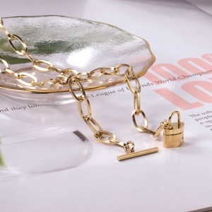 Chunky 18k gold plated lock pendant necklace with a toggle clasp on a magazine
