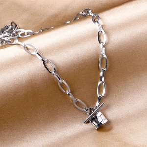 Silver stainless steel chain necklace with toggle clasp and cylindrical pendant on satin