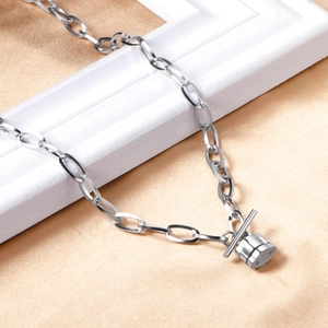 Macro detail of silver link chain necklace with toggle clasp on champagne satin