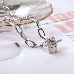 Detail view of silver stainless steel thick chain necklace with T-toggle clasp and pendant