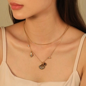 Collana a due strati color oro con ciondoli a stella e luna indossata da una modella