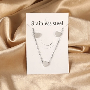 Polished stainless steel jewelry set featuring a heart pendant necklace and stud earrings