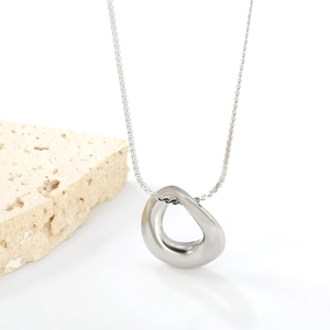 Nahaufnahme des unregelmäßigen Tropfenanhängers an einer Edelstahlkette im Minimal-Stil
