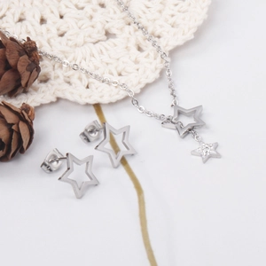 Détail macro du collier pendentif pentagramme argenté et boucles d'oreilles étoiles