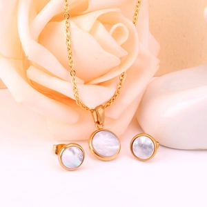 Détail de parure collier et boucles d'oreilles dorés avec nacre blanche ronde élégante
