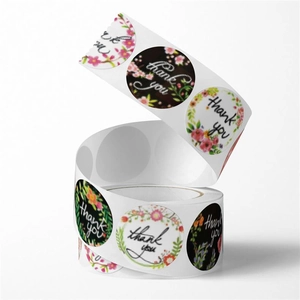 Macro detail of round floral Thank You stickers on a roll for gift packaging