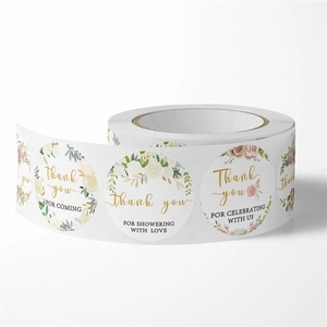 Close-up of floral thank you stickers roll with elegant rose patterns for gift packaging