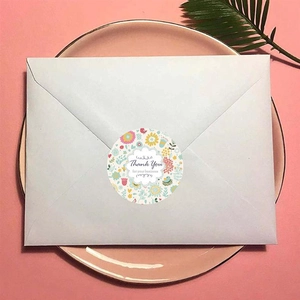 Detailed view of floral Thank You sticker sealing a light blue envelope for wedding gift