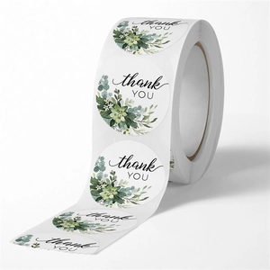 Detail of round green floral thank you stickers roll for wedding gift packaging seals