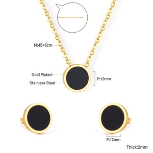 Detail of gold plated stainless steel necklace and earrings set with black enamel inlay