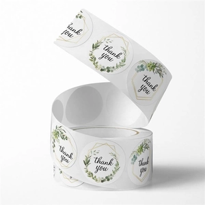 Macro view of round floral thank you stickers in a roll with gold geometric leaf designs