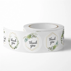 Macro detail of round thank you labels with green succulent designs and gold geometric frames