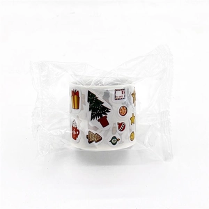 Close-up of Christmas sticker roll in clear bag featuring trees gifts and festive patterns