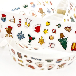 Close-up of rolled Christmas stickers with Santa, reindeer and snowflake patterns