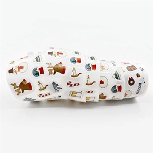 Close-up of a roll of colorful cartoon Christmas stickers with Santa and reindeer designs
