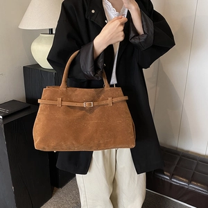Retro brown matte suede tote bag with decorative buckle shown in a modern lifestyle setting