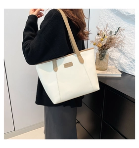 Detail of a large cream tote bag with camel contrast straps and Fashion leather tag