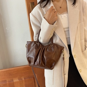 Sac seau plissé en cuir marron foncé avec poignées métalliques et bandoulière amovible