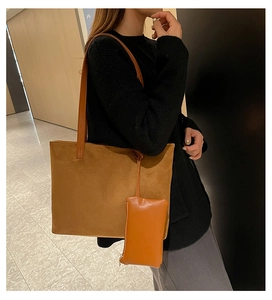 Detail of dark brown suede tote bag with slim straps and matching mini pouch