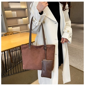 Detail view of large dark brown suede tote bag and matching pouch on white trench coat