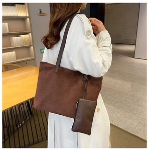 Brown suede tote bag with small pouch shown on model wearing a white long coat