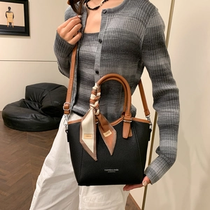 Sac seau tendance en cuir noir avec poignée marron et détail de foulard en soie floral