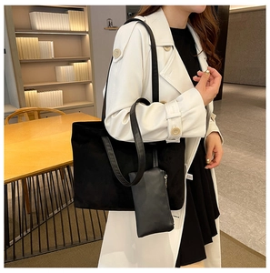 Detail view of black faux suede tote bag and matching zipper pouch for daily commuting