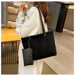 Detail of black suede tote bag and matching pouch showing soft texture and large capacity