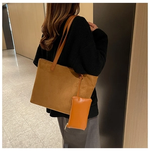 Detailed close-up of brown suede tote bag featuring texture and matching zip pouch