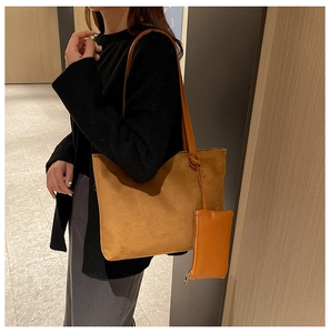 Detail of brown suede tote bag featuring knot shoulder strap and detachable pouch