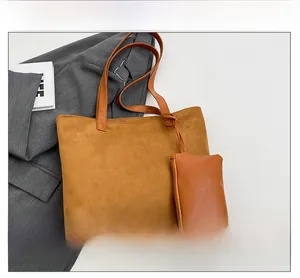 Close-up of brown suede tote bag with matching zippered pouch and leather straps