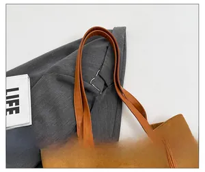 Close-up of the caramel suede tote bag handle showing stitching and knotted leather details